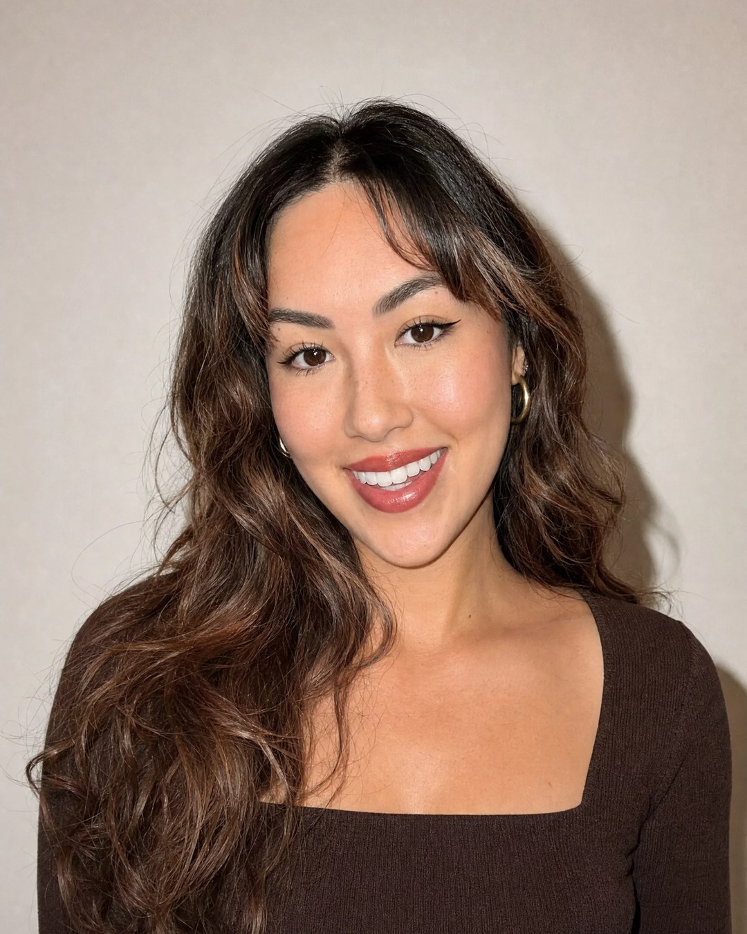 Gracey, founder of DealCheats, smiling in a brown top